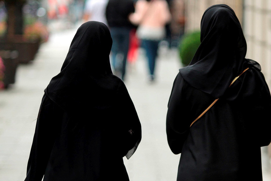 Zwei Frauen mit Burka schlendern durch die Straßen.