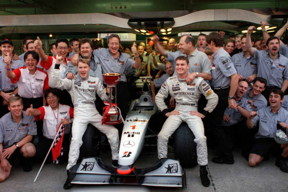 November 1998: Mika Hällinen (Mitte links) und David Coulthard (Mitte rechts) bejubeln mit McLaren-Mercedes-Team- und Motorsportchef Norbert Haug (hinter Häkkinen) den Titelgewinn im japanischen Suzuka.