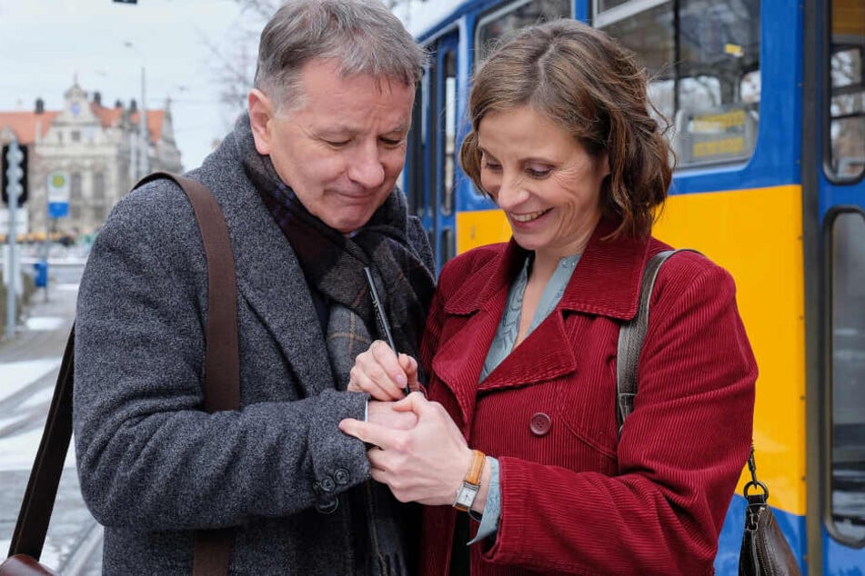 Dr. Roland Heilmann (gespielt von Thomas Rühmann) lässt sich Katja Brückners (Julia Jäger) Nummer auf die Hand schreiben.
