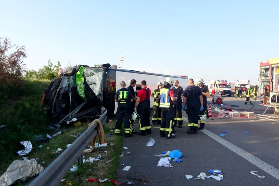 Rettungskräfte stehen vor dem umgekippten Flixbus. Insgesamt mussten 72 Verletzte versorgt werden.