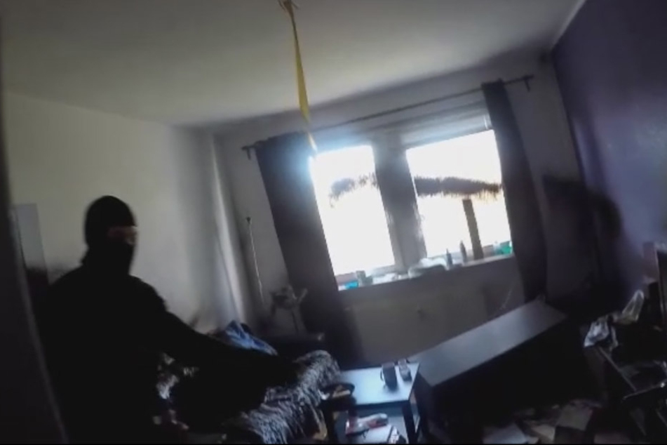 Hier versprüht ein Angreifer schwarze Farbe im Zimmer.
