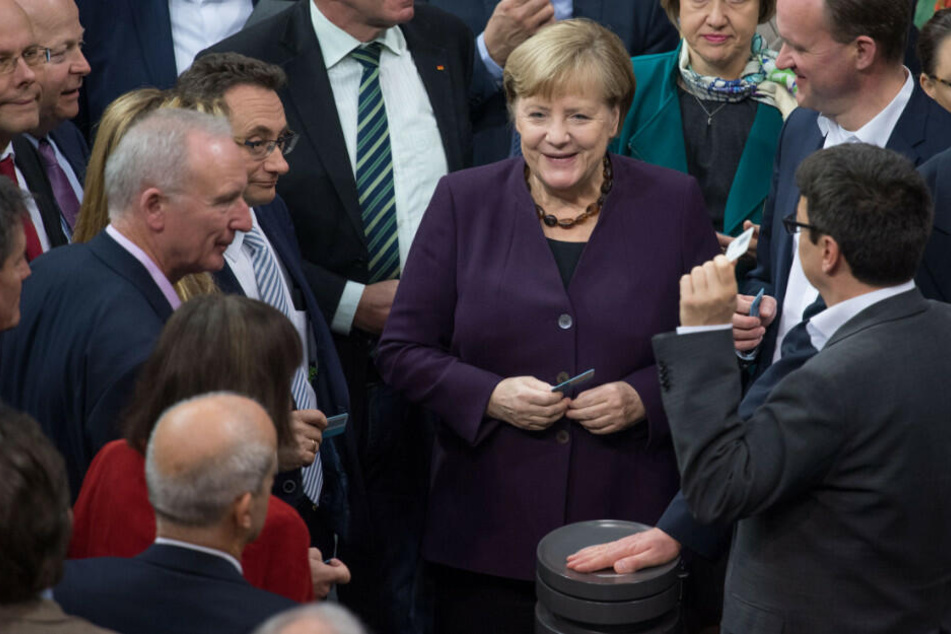 Bundeskanzlerin Angela Merkel (CDU) und weitere Abgeordnete stimmen bei der 128. Sitzung des Deutschen Bundestages namentlich ab.