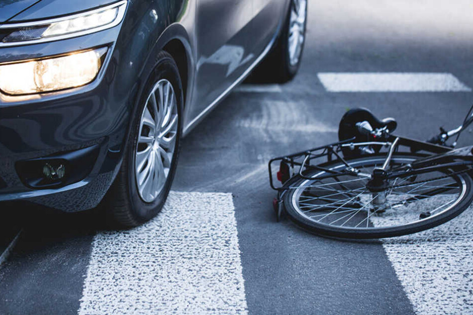 Das Radfahrer wollte Ein Fahrrad liegt nach einer Kollision mit einem Auto auf der Straße. (Symbolbild)