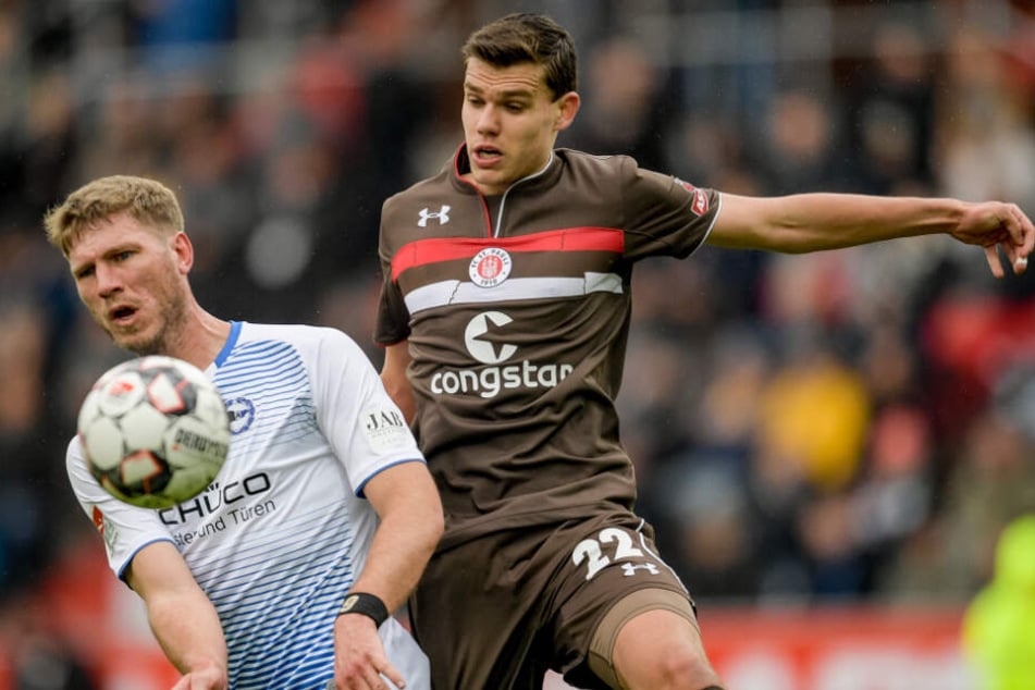 St. Paulis Abwehrspieler Justin Hoogma kommt gegen Bielefelds Angreifer Fabian Klos nicht an den Ball.