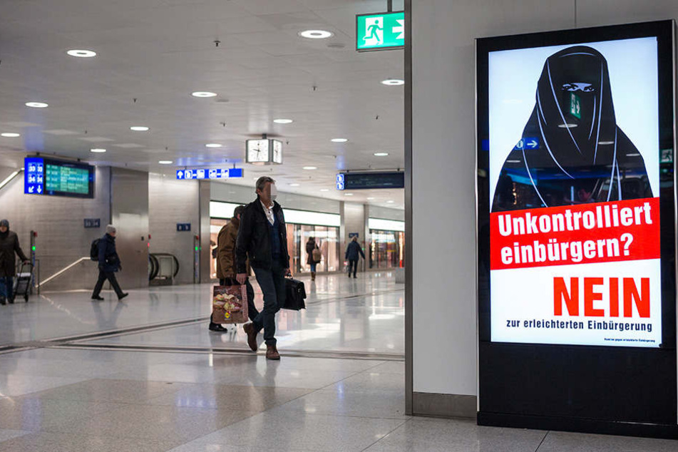 Ein Plakat mit einer vollverschleierten Frau hängt im Züricher Hauptbahnhof.