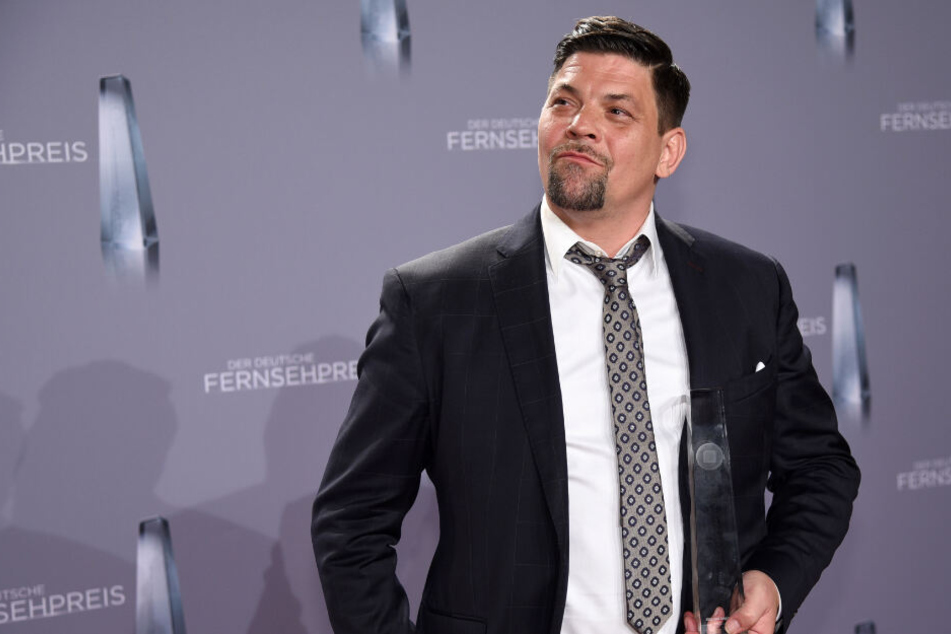 Tim Mälzer hält nicht nur einen Preis in der Hand, als Patenonkel darf er auch den Nachwuchs von Sänger Sasha auf den Arm nehmen.