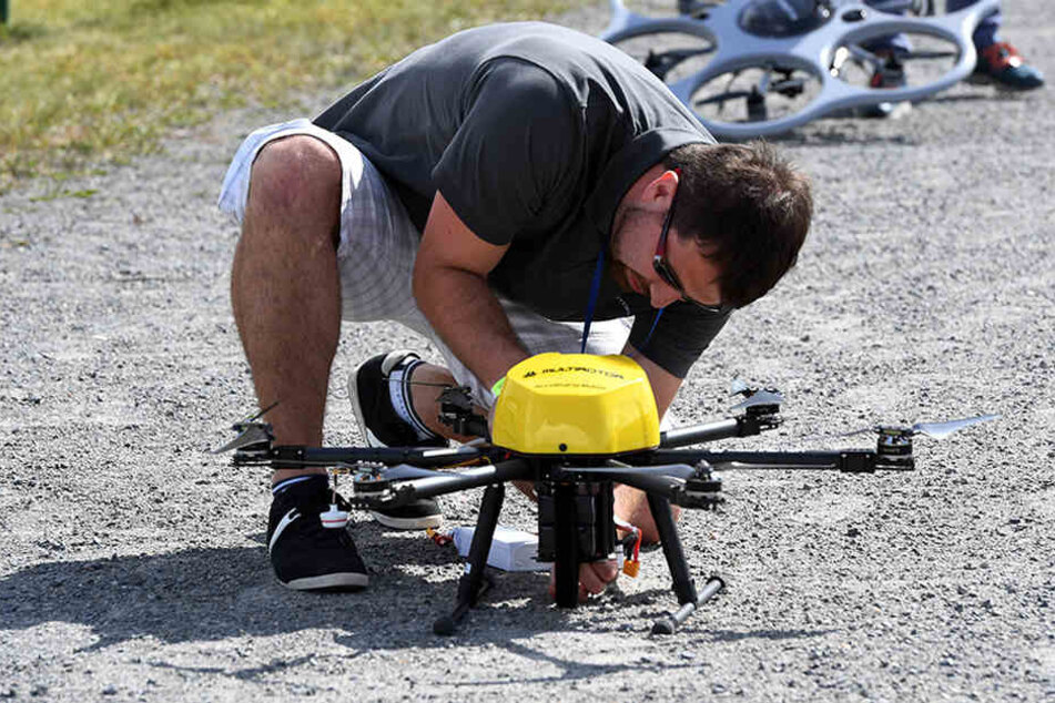 in Mann justiert bei dem Dronemasters Dronathon in Berlin eine Multicopter-Drohne.