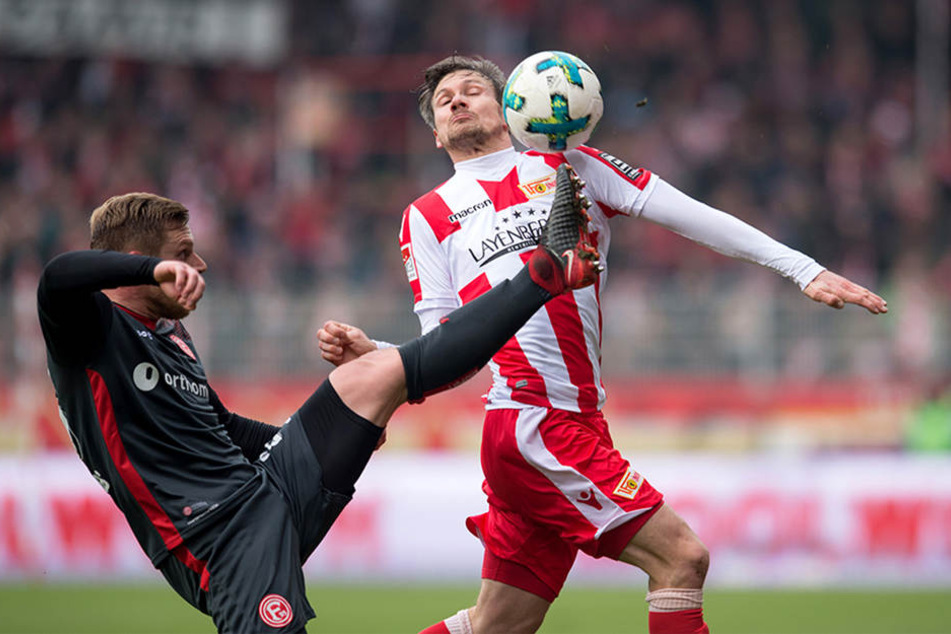 Düsseldorfs Rouwen Hennigs (l) streckt den Fuß zum Ball gegen Unions Michael Parensen.
