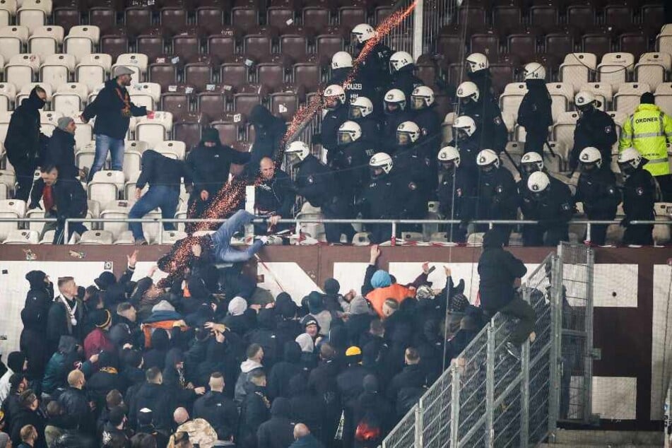 Polizeikräfte drängen randalierende Fans von Dynamo Dresden zurück in den Gästeblock.