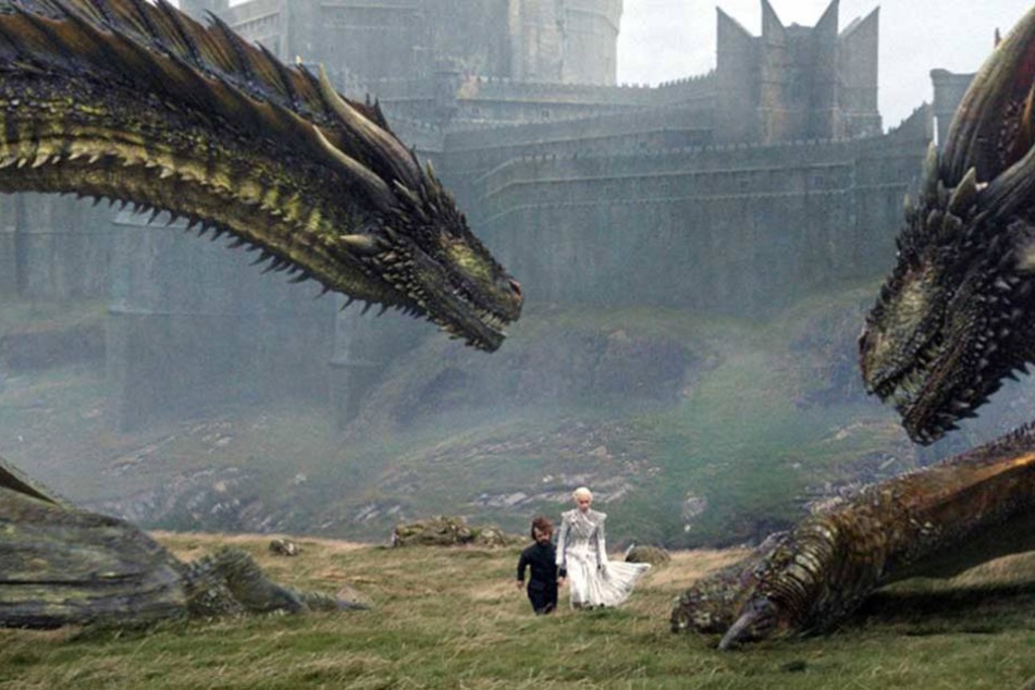 Szene aus Game of Thrones: Tyrion Lannister und Daenerys Targaryen werden von ihren Drachen flankiert.