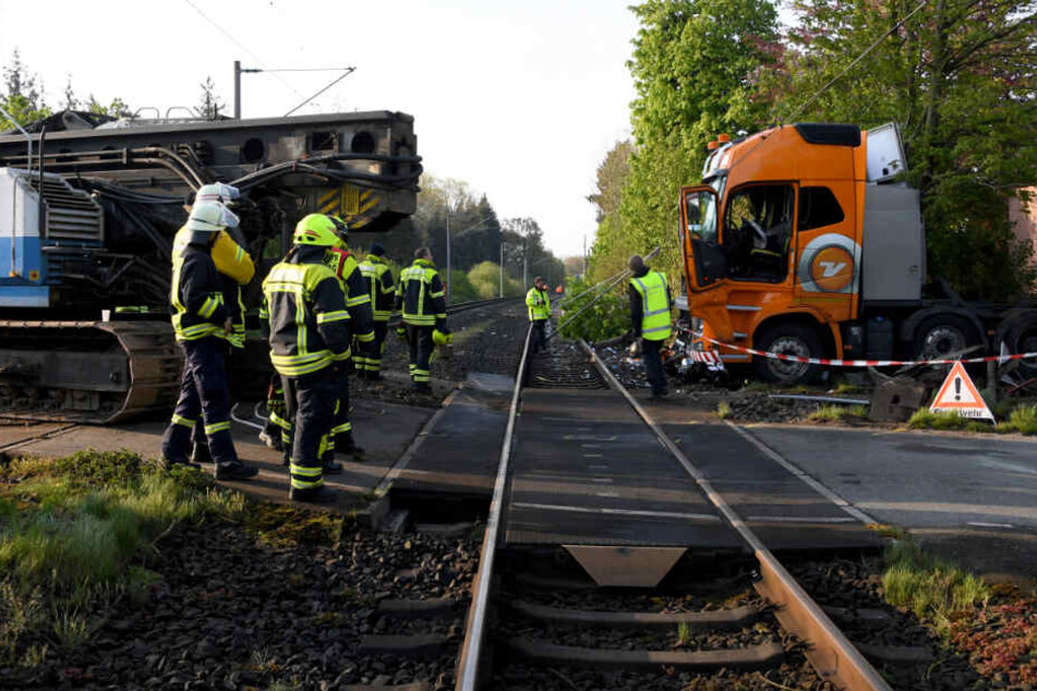 Die Einsatzkräfte stehen an der Unfallstelle, am Lkw sind die Spuren des Zusammenpralls deutlich zu sehen.