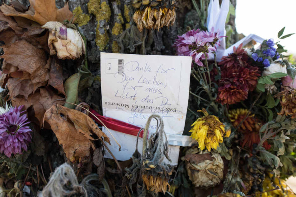 Blumen und Trauerschmuck hängen an einem Baum an der Dreisam. Hier soll der Täter sein Opfer getötet haben.