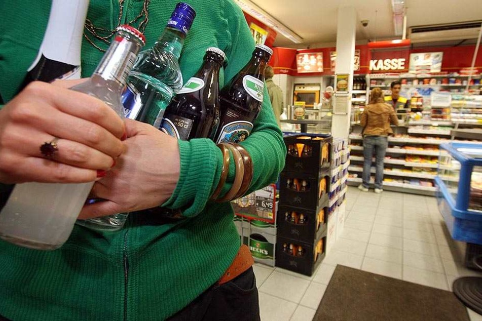 Eine junge Frau schleppt Bier und Schnaps aus einer Tankstelle. Die Aktion Jugendschutz wünscht sich mehr Kontrollen (Symbolbild).