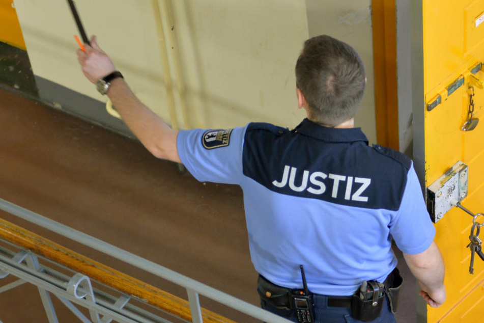 Ein Justizvollzugsbeamter steht in der Justizvollzugsanstalt Moabit in Berlin vor einer geöffneten Zellentür.