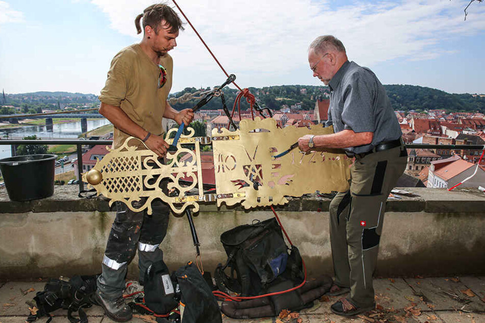 Die Alpinetechniker Matthias Wagner und Gunther Steinmann (v.l.) hingen die Fahne an die Kletterseile, damit sie nach oben gezogen werden konnte.