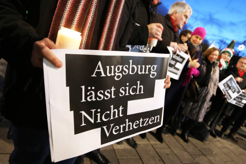 Menschen demonstrieren in Augsburg gegen politische Instrumentalisierung.