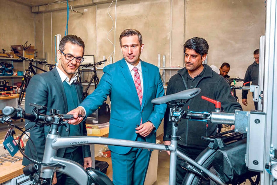 Flüchtling Aminzadeh Khosro (36, r.) wird zum Monteur geschult. Wirtschaftsminister Martin Dulig (44, SPD) lobte "Fahrrad XXL Emporon"-Geschäftsführer Hamidreza Ameli (46, l.) für sein innovatives Job-Projekt.