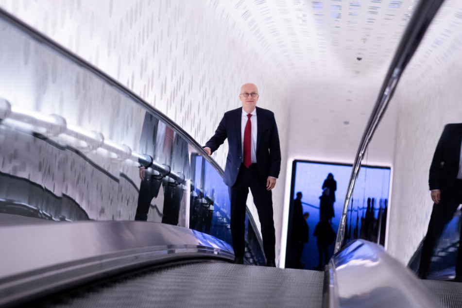 Peter Tschentscher fährt die Rolltreppe in der Elbphilharmonie hinauf.