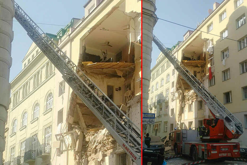 Ein Feuerwehrauto steht mit ausgefahrener Leiter vor einem teilweise eingestürzten Mehrfamilienhaus.
