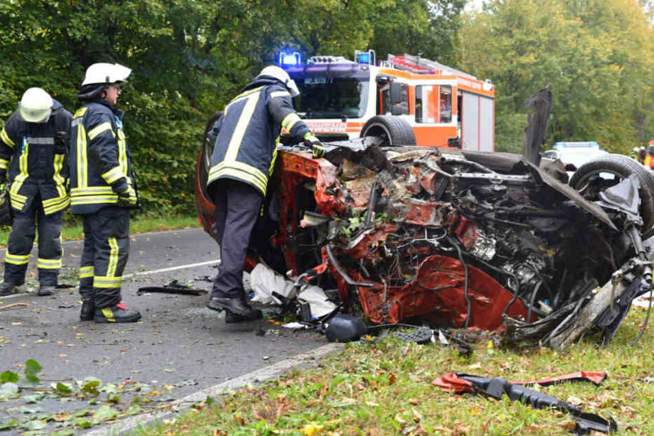 Einsatzkräfte bei den Überresten des Unfallwagens.