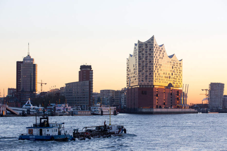 Die Elbphilharmonie leuchtet in der aufgehenden Sonne.