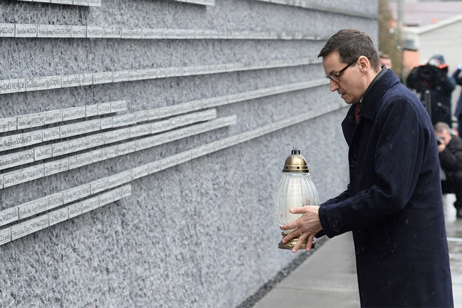 Mateusz Morawiecki, Ministerpräsident von Polen, stellt eine Kerze an ein Denkmal, das an Polen erinnert, die während des Holocaust Juden gerettet haben.