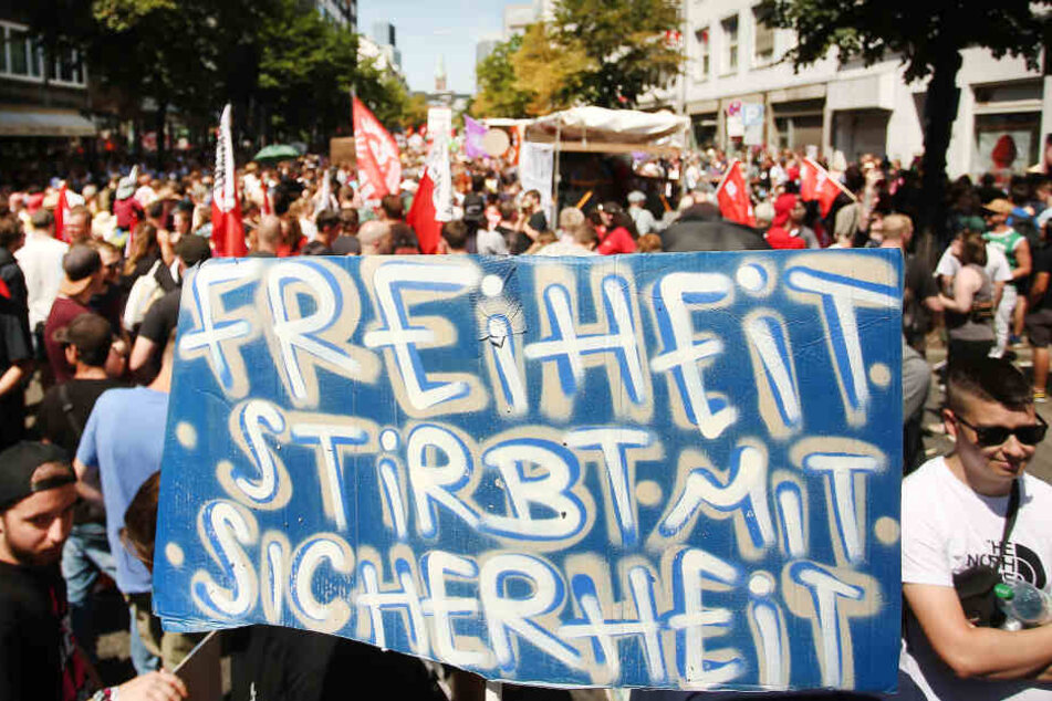"Freiheit stirbt mit Sicherheit" steht auf dem Schild von Demonstranten, die auf der Friedrich-Ebert-Straße in Düsseldorf gegen das geplante neue Polizeigesetz protestieren.