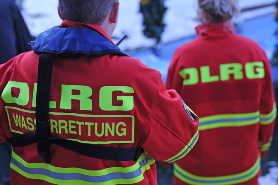 Helfer der DLRG Wasserrettung stehen an einem Badesee.