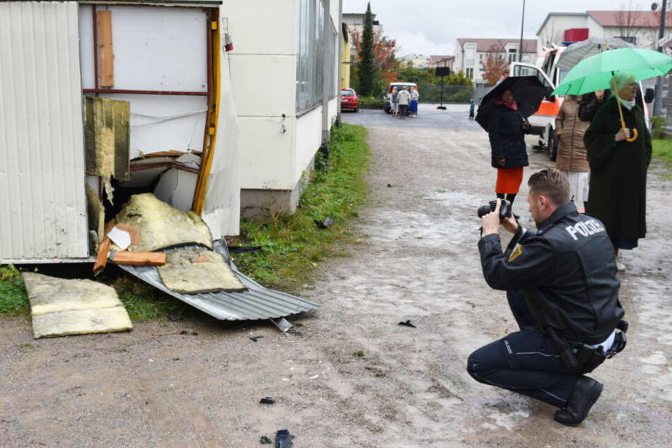 Nachdem sie bereits den Zaun durchbrochen hat, rast die Frau mit ihrem Wagen gegen diesen Container.