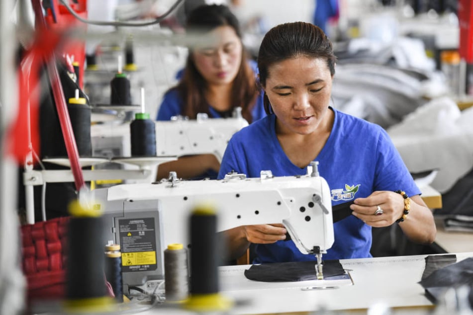 Arbeiterinnen stellen Kleidung in einem Bekleidungsunternehmen in China her.