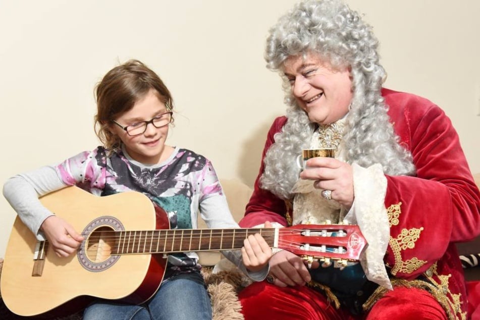 Ronja spielt August ein Lied auf der Gitarre vor. Seit einem Jahr nimmt die Prinzessin Instrumentenunterricht.