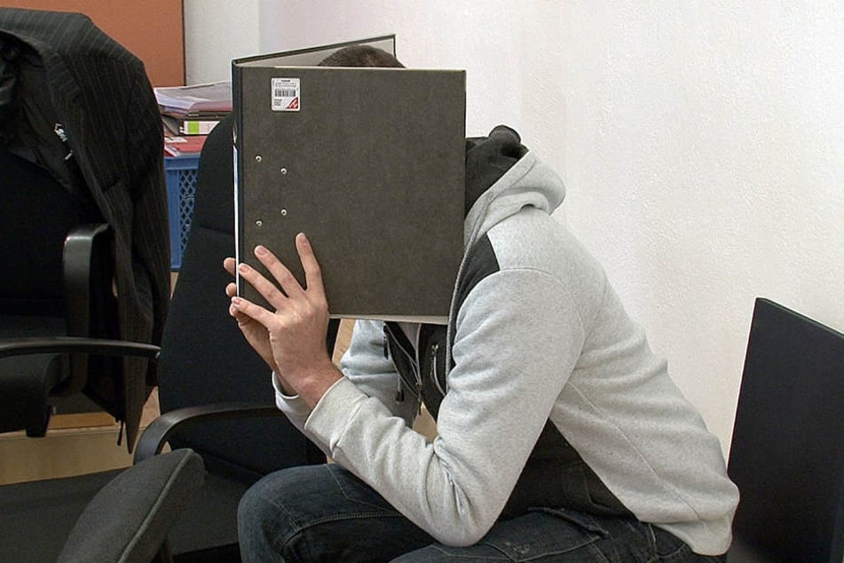 Der mutmaßliche Brandstifter versteckte sein Gesicht im Prozess hinter seiner
Akte.