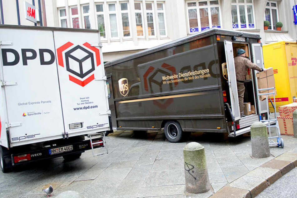 Transportwagen der Logistikunternehmen DPD, UPS (United Parcel Service) und DHL stehen in der Innenstadt von Hamburg.