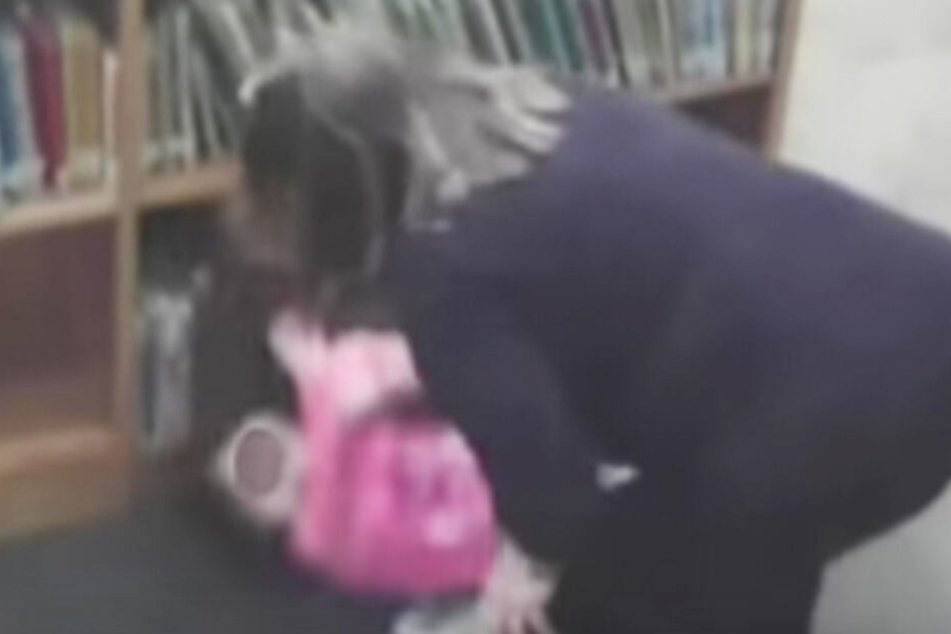 Auf den Videoaufnahmen ist zu sehen, wie die Lehrerin das Mädchen aus dem Bücherregal zerrt.