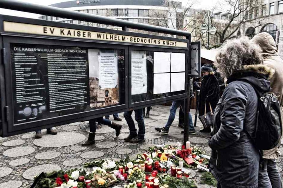 Menschen legen Blumen am Breitscheidplatz in Berlin ab und zünden Kerzen an, um den Opfern zu gedenken.