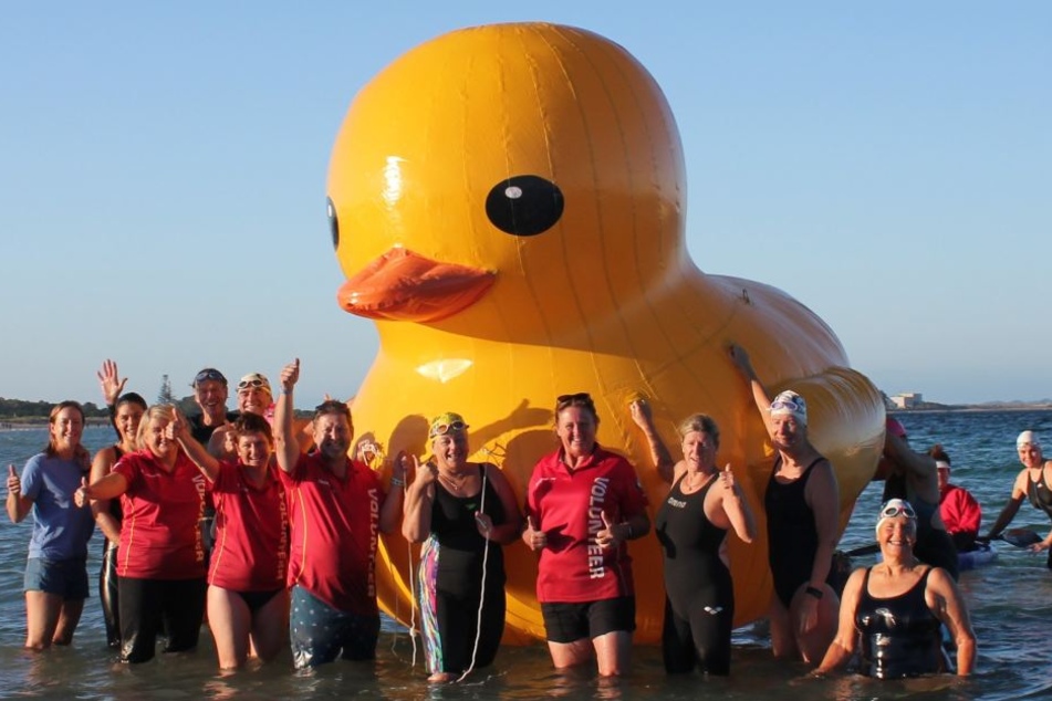 Mitglieder stehen um die Ente Daphne, des Maskottchen des australischen Schwimm-Clubs Cockburn Masters Swimming Club.