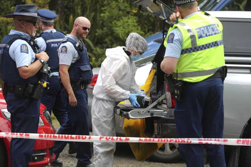 Polizisten stehen hinter einer Absperrung entlang eines Abschnitts des "Scenic Drive" in der Waitakere Bergkette.