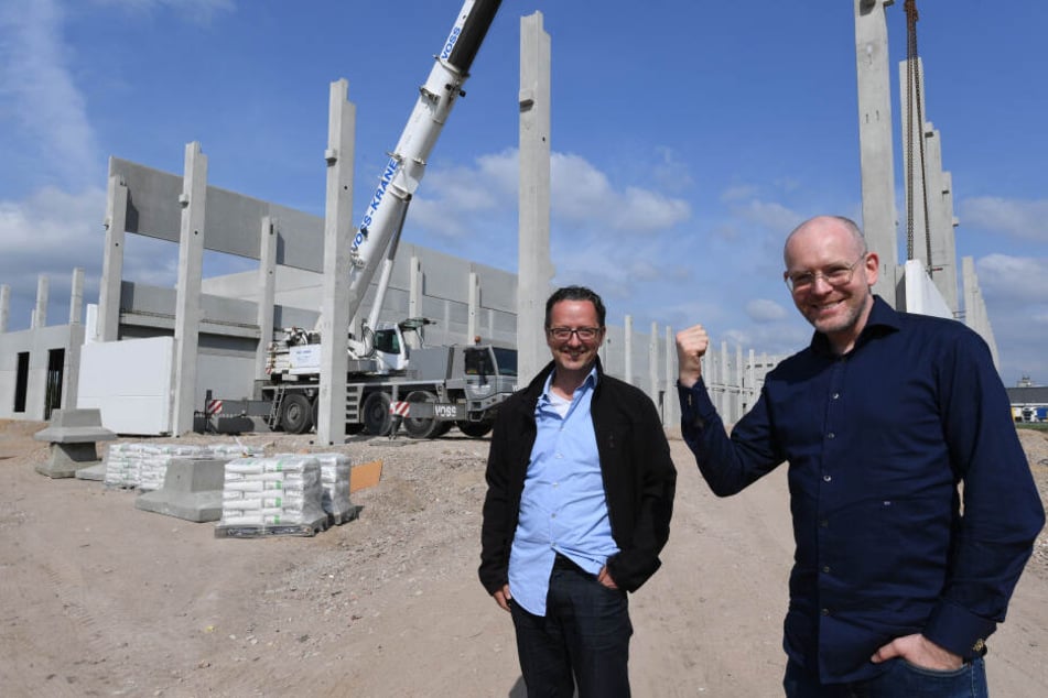 Hendrik Knopp (r), Geschäftsführer des Betreibers Aphria Deutschland GmbH und Thorsten Kolisch, Baustellenleiter, stehen vor dem Rohbau einer Halle.