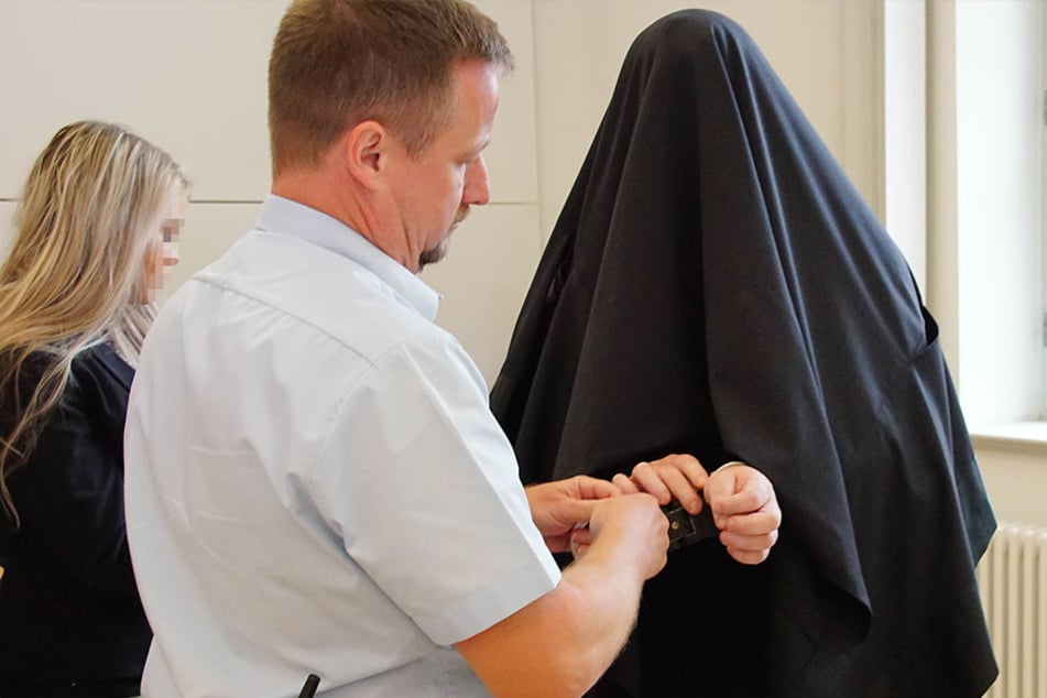 Unter einem schwarzen Tuch versteckte sich Richard G. (34) vor der Presse.