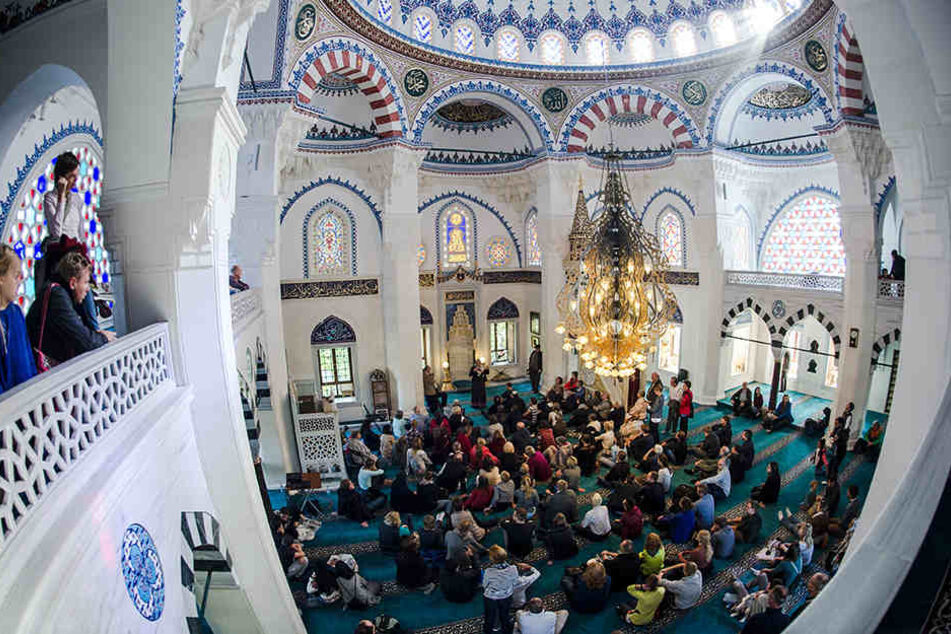 Zahlreiche Besucher sitzen am 03.10.2015 in Berlin beim bundesweiten "Tag der offenen Moschee" in der Sehitlik-Moschee.