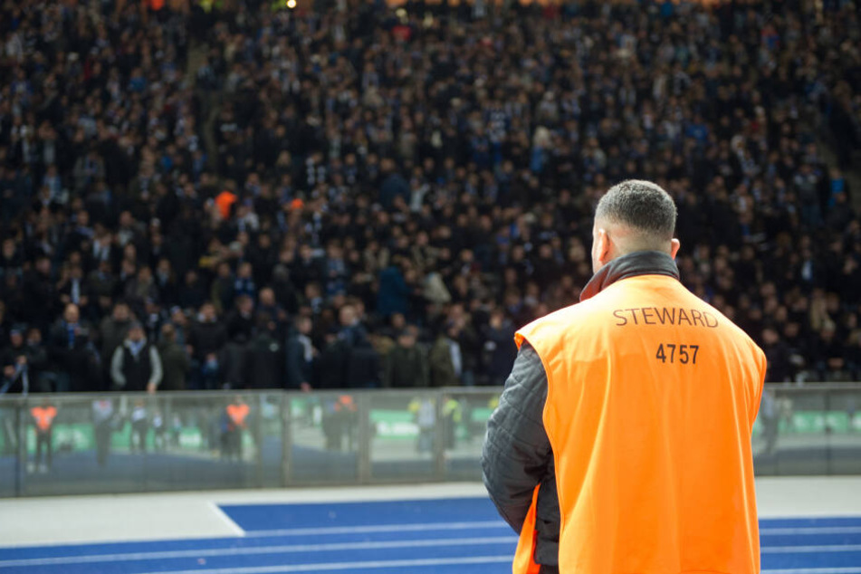 Ein Ordner steht im Berliner Olympiastadion vor der Ostkurve.