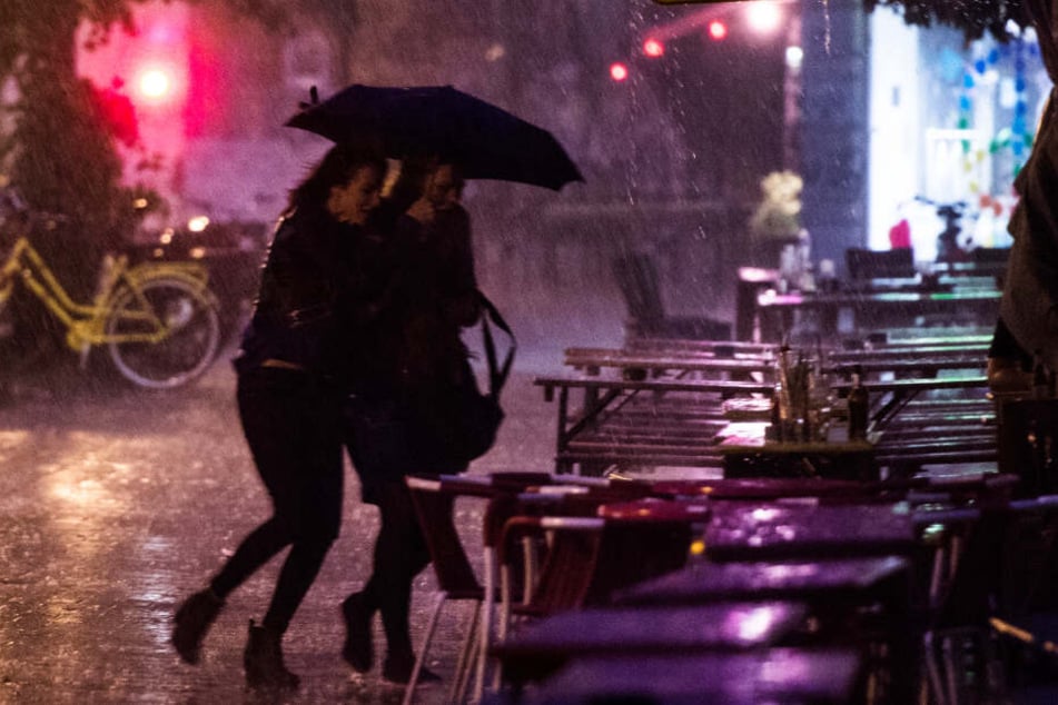 Zwei Frauen flüchten auf der Sternschanze durch starken Regen. (Archivbild)