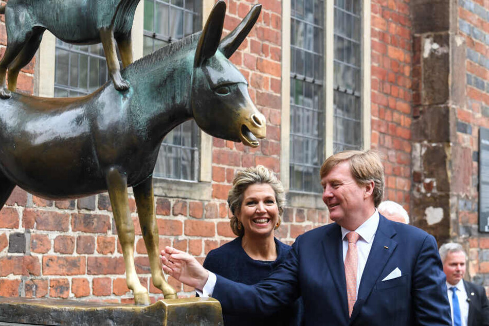 Das niederländisches Königspaar Willem-Alexander und Maxima stehen bei ihrem Bremen-Besuch an der Figur der Bremer Stadtmusikanten.