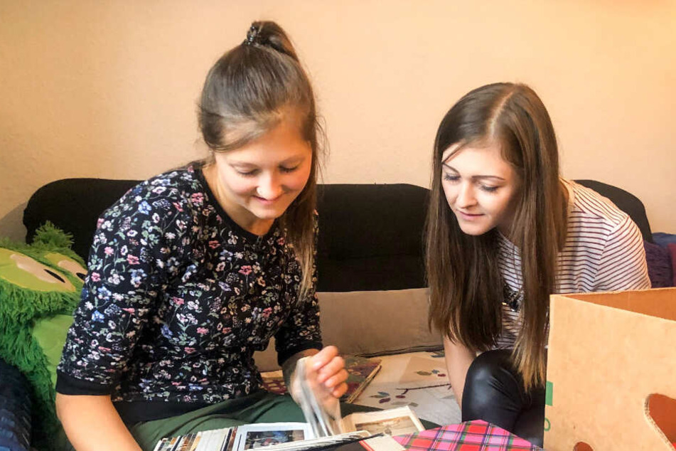 Jenny (27, r.) und Jessica (24), Jens' Töchter aus erster Ehe, blättern in alten Fotoalben.