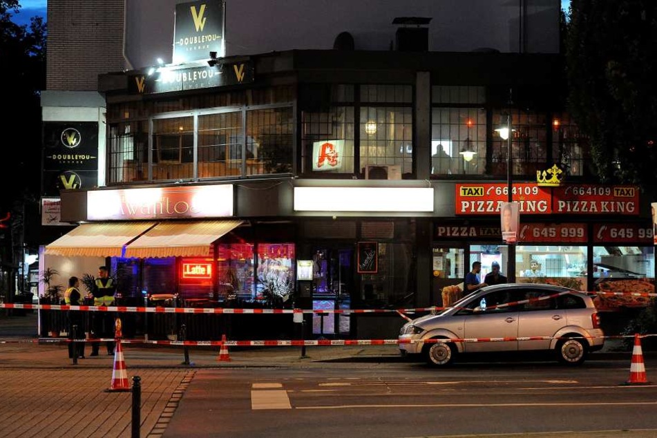 Polizisten stehen vor dem Bistro, wo ein 42-Jähriger nach einem Streit mehrmals auf einen 53-Jährigen eingestochen und ihn lebensgefährlich verletzt haben soll.