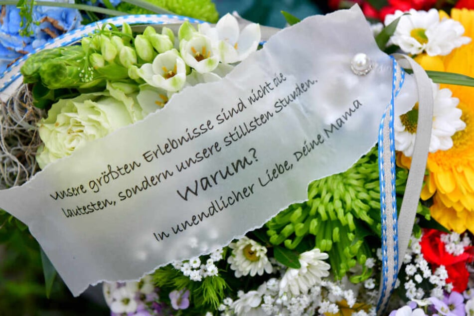 Ein Spruchband auf einem Blumengebinde von der Mutter des Opfers liegt bei der Trauerfeier am Grab des Jungen.