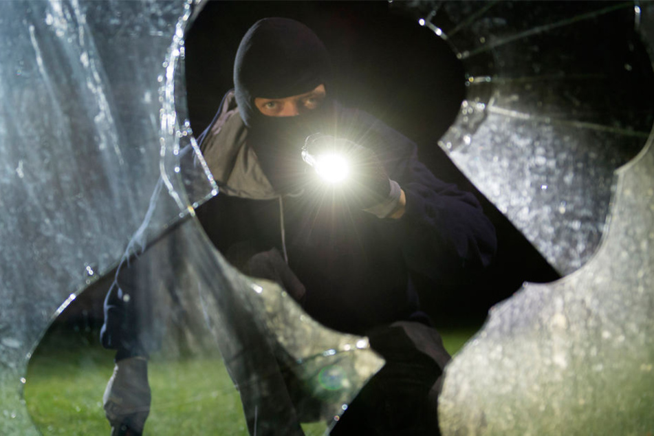 Über ein zerbrochenes Fenster gelangten die drei maskierten Männer ins Geschäft. (Symbolfoto)