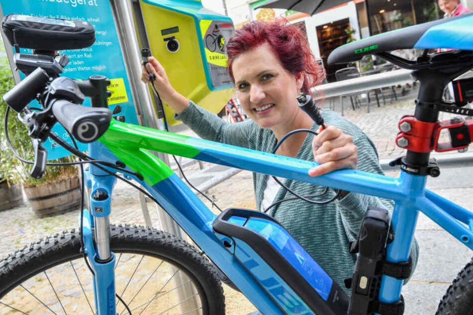 Erfolgreiche Premiere: Melanie Günther (35) von der Firma Göbau aus Wilkau-Haßlau nimmt auf dem Hauptmarkt die erste Zwickauer Ladesäule für E-Bikes in Betrieb.
