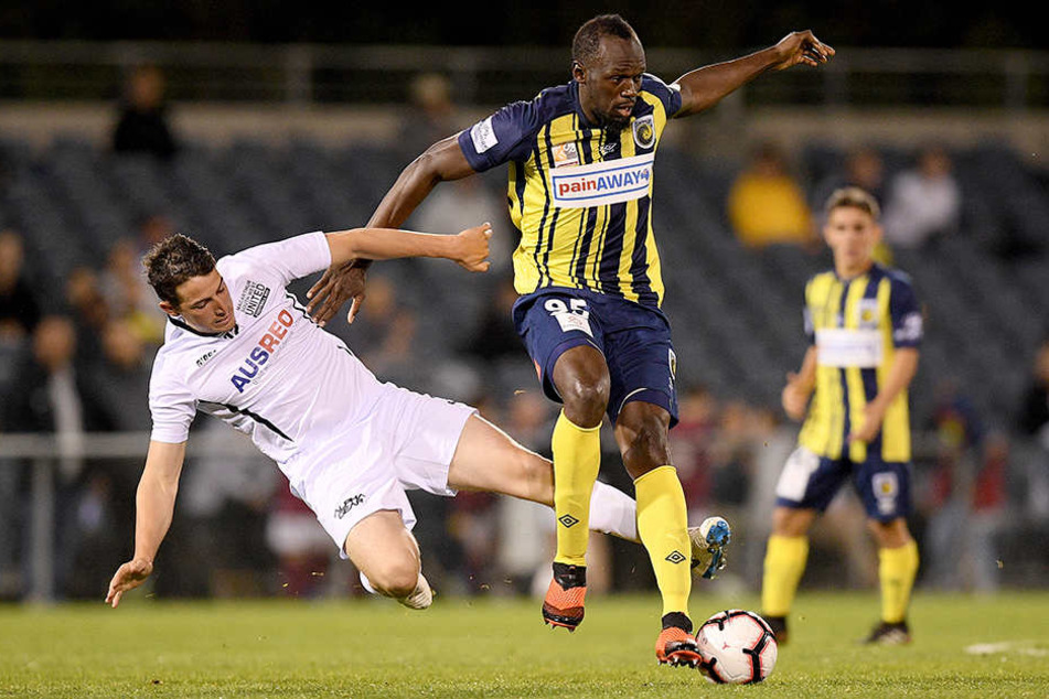 Usain Bolt (r.) behauptet sich im Zweikampf gegen Josh Symons von Macarthur South West United.