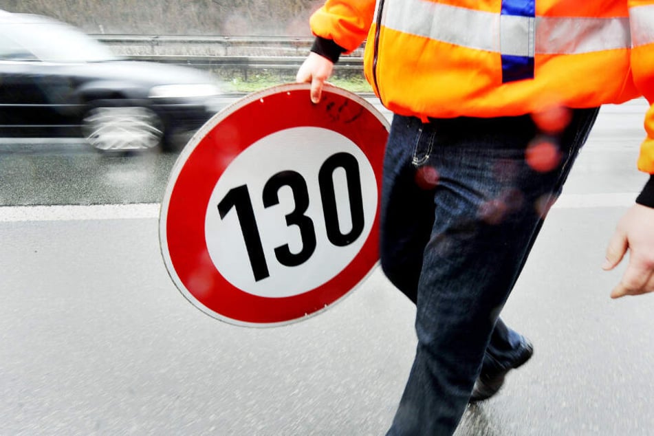 Ein Mitarbeiter der Autobahnmeisterei trägt auf der Autobahn 661 bei Frankfurt ein Schild zur Höchstgeschwindigkeit von 130 Stundenkilometern.